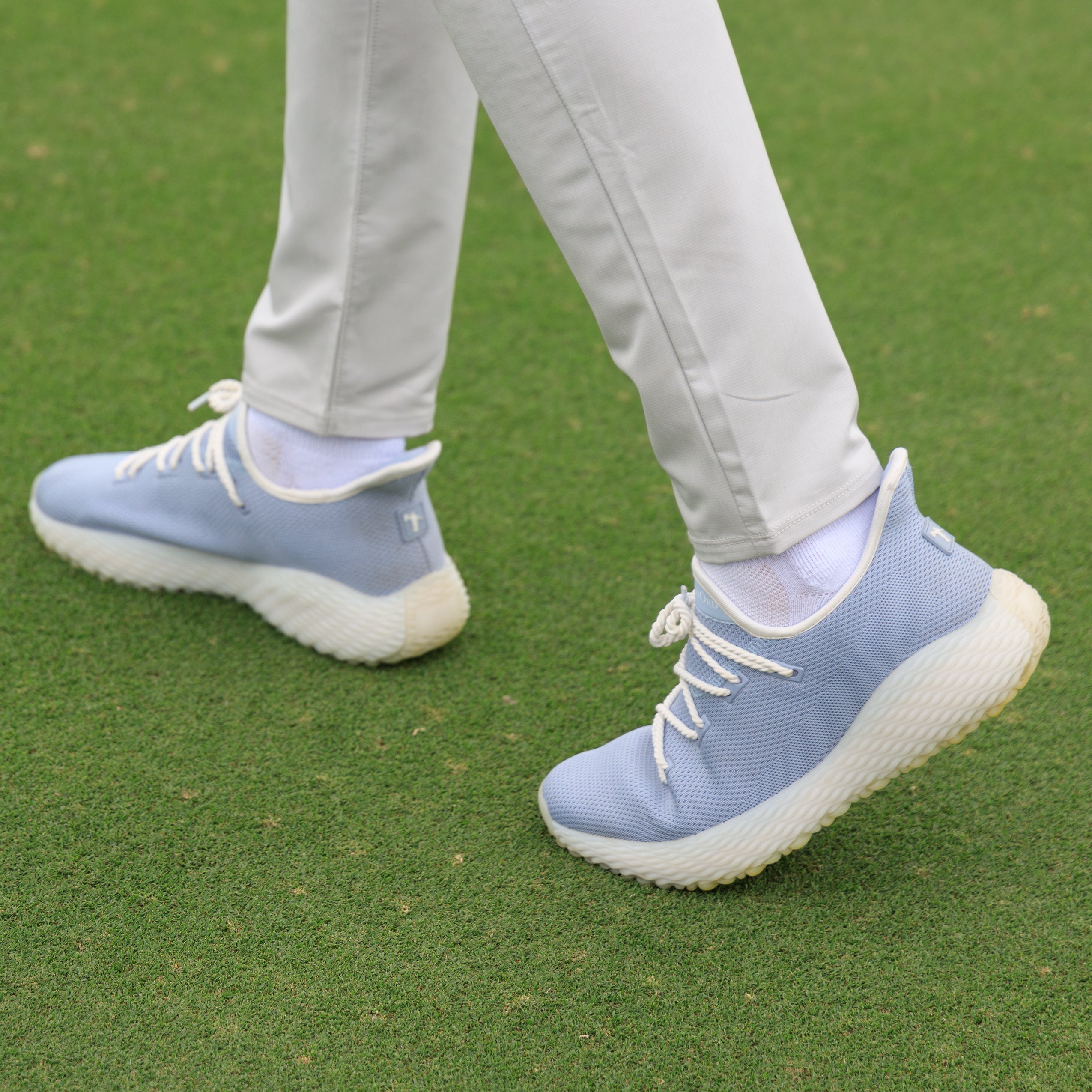 man on fairway wearing light blue golf shoe. Casual mens golf shoe. Pickleball shoe for men in light blue. The AO WAVE1, The Ultimate Crossover Performance Shoe.